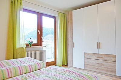 Schlafzimmer mit Doppelbett und Zugang zum Balkon